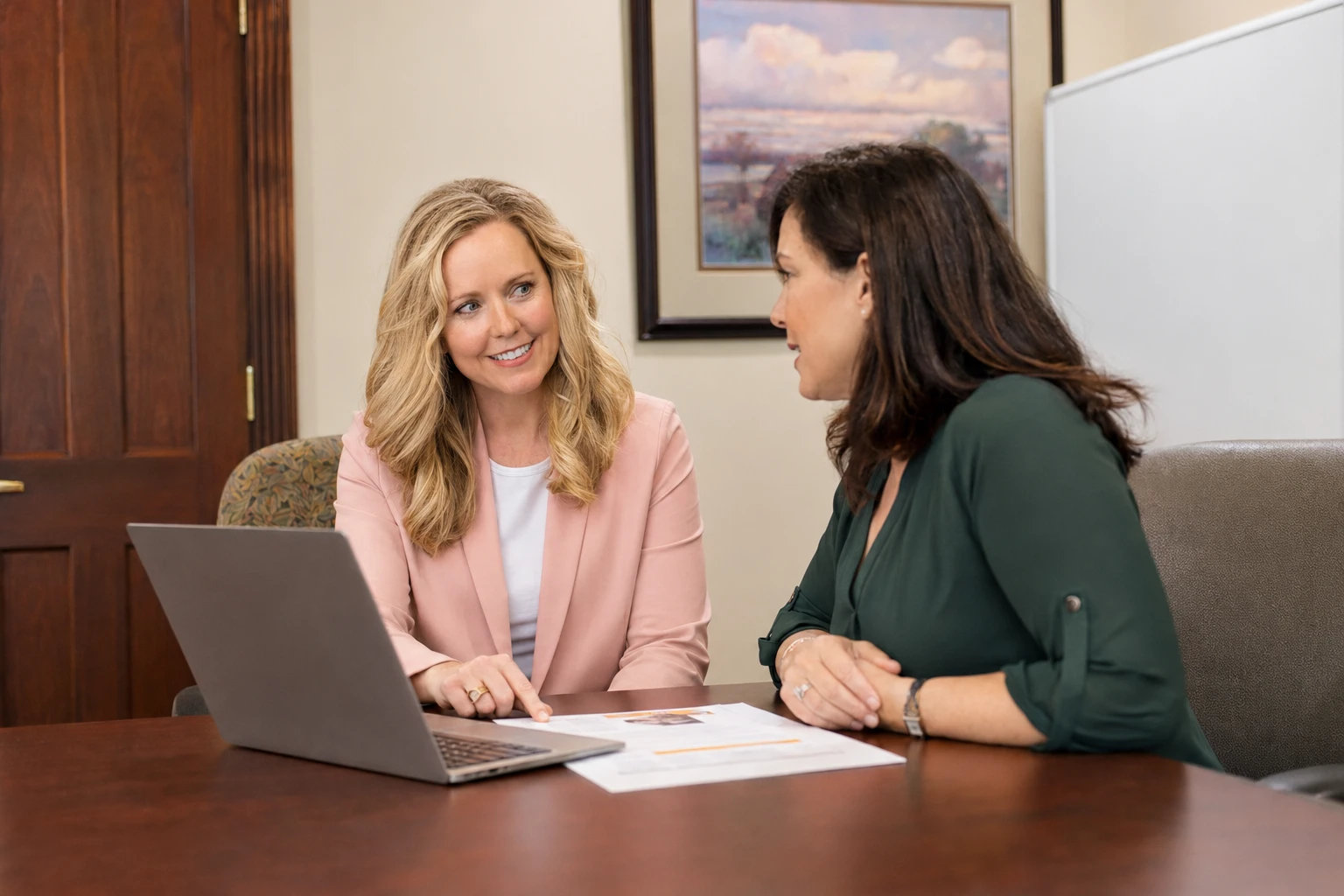A Cooper Norman advisor and client review accounts together on a laptop.