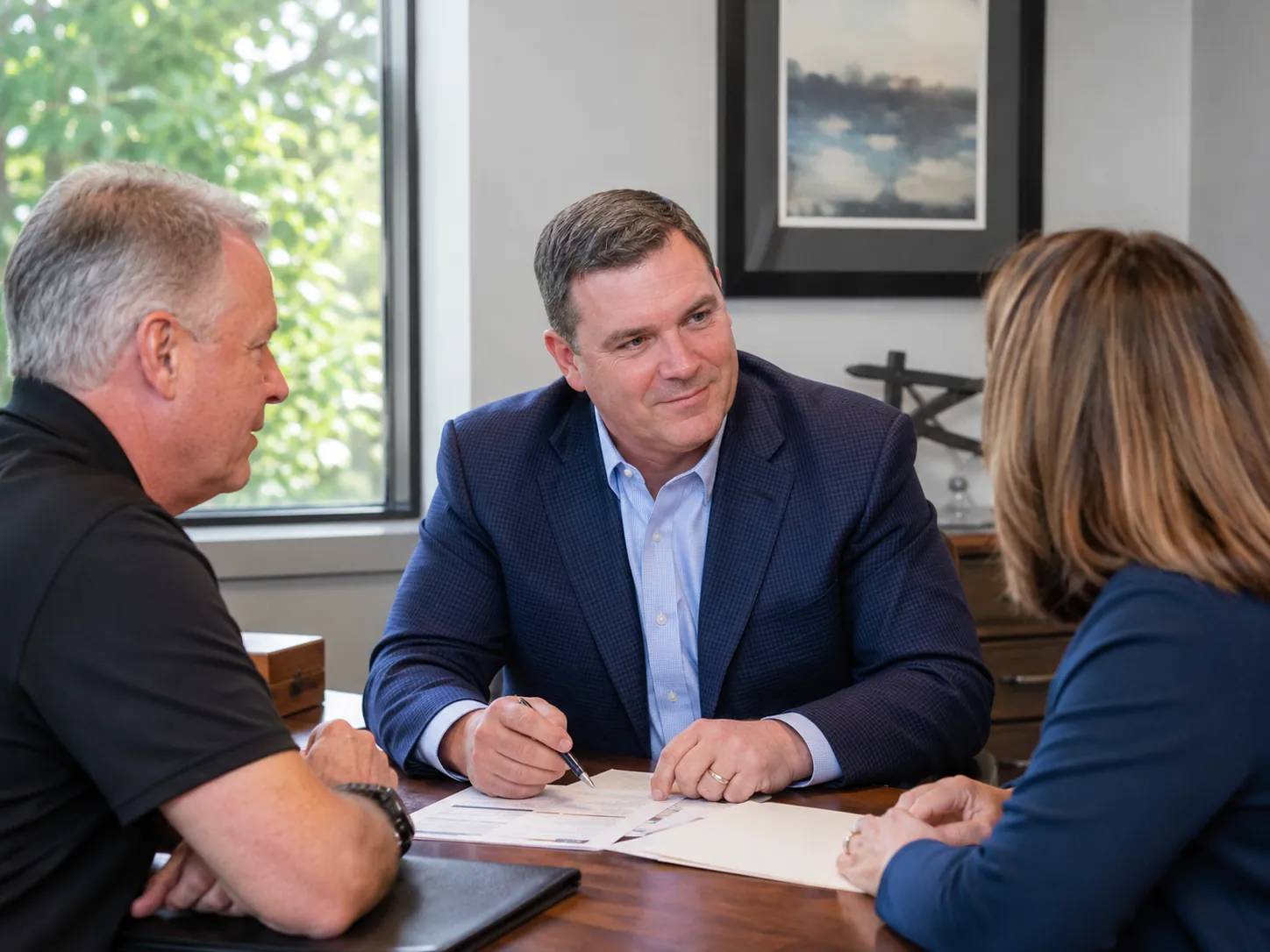 Cooper Norman advisor reviewing financial documents with clients.